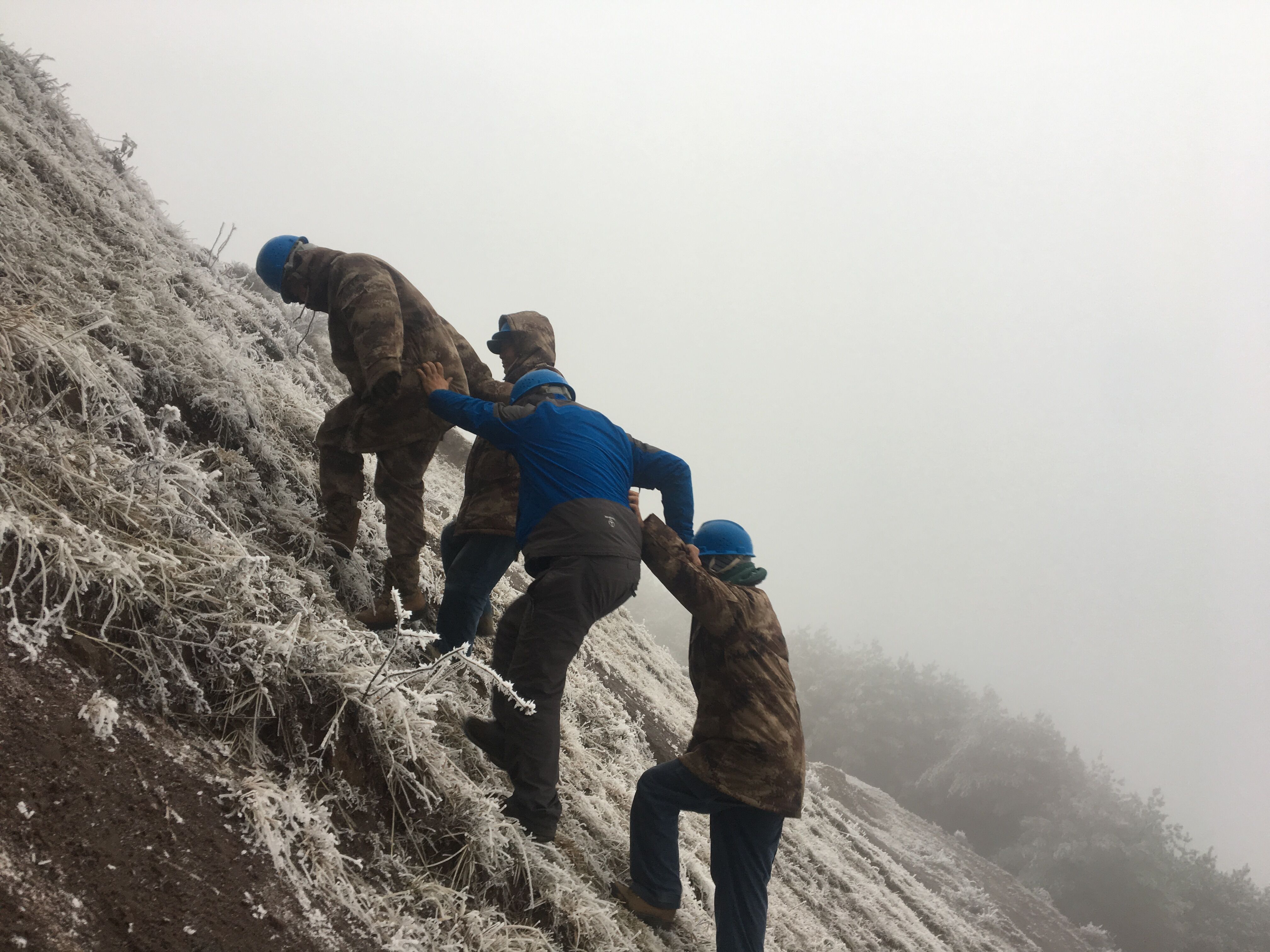 互相搀扶，勇登高峰。（李健摄）