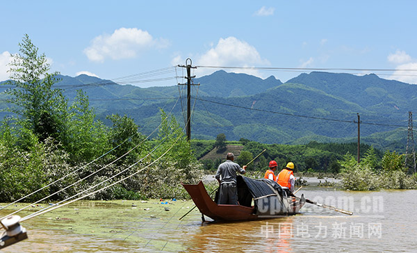 图为抢修人员赶往水淹地区，排查线路隐患。