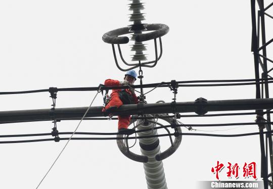图为电力工人在70多米高空作业，为特高压复奉线重庆段进行八年来首次大修。　周毅 摄