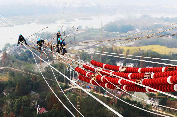 国网安徽电力施工人员在安徽芜湖市南陵县的80多米高空进行导线附件安装施工。（郑贤列摄）